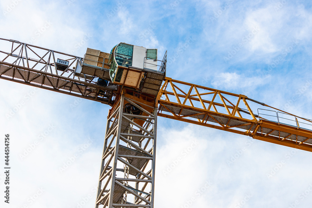 Tower crane close-up on a background of blue sky. Modern housing construction. Industrial engineering. Construction of mortgage housing.