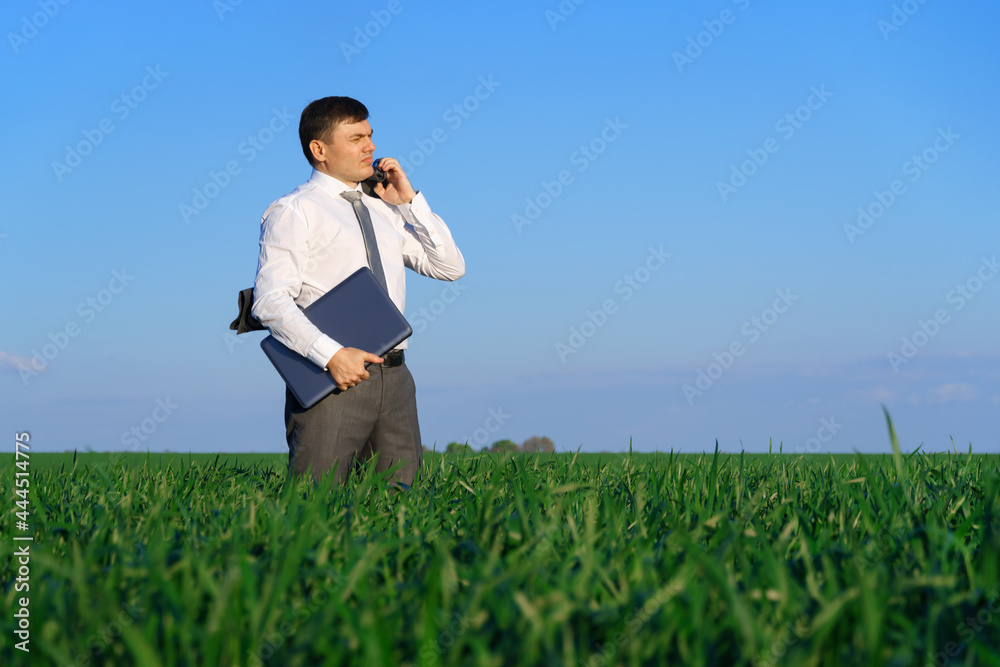 businessman works in a green field, freelance and business concept, green grass and blue sky as background businessman works in a green field, freelance and business concept, green grass and blue sky as background