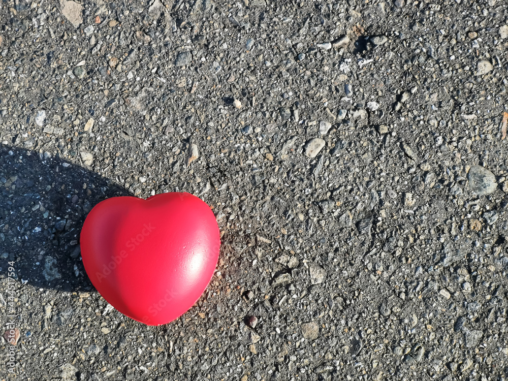 Fototapeta premium Red heart shape isolated on asphalt road with copy space.