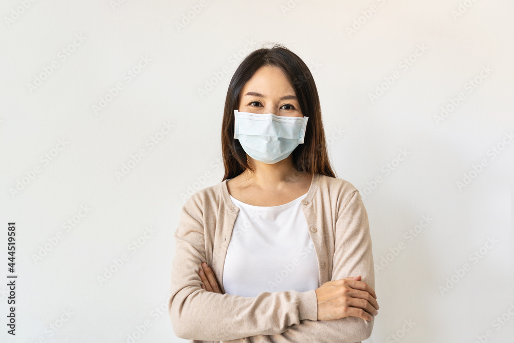 Portrait of beautiful young Asian woman wearing a surgical mask during the crisis of the coronavirus pandemic on white background. New normal lifestyle, health care concept. Copy space Portrait of beautiful young Asian woman wearing a surgical mask during the crisis of the coronavirus pandemic on white background. New normal lifestyle, health care concept. Copy space