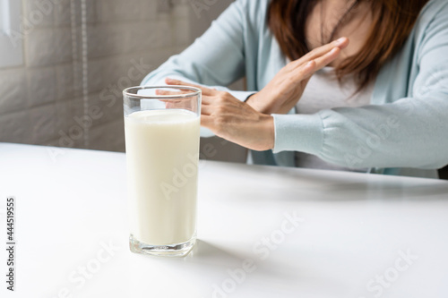 Female making X sign with crossed hands, gesturing stop or say no to drink milk. Lactose intolerance, food allergy concept.
