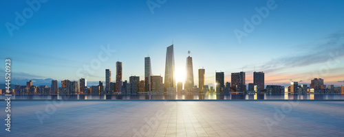 Panoramic view of empty concrete tiles floor with city skyline.