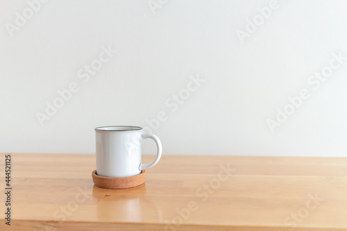 White cup of hot coffee mug on wooden table with isolate white background.