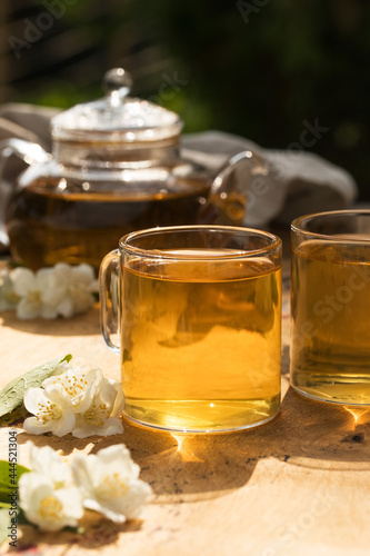 Green Chinese tea with jasmine in a mug with jasmine flowers.
