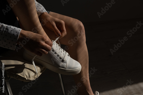 Woman put on new white leather sneakers