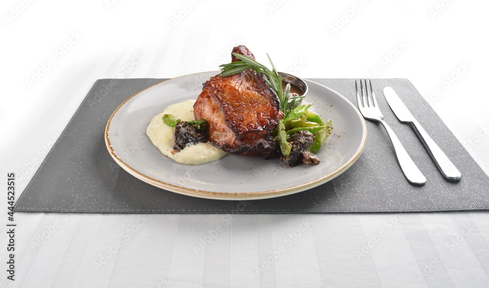 Texas grilled chicken leg confit with vegetables, mash potato and chef brown sauce in white background western main course menu