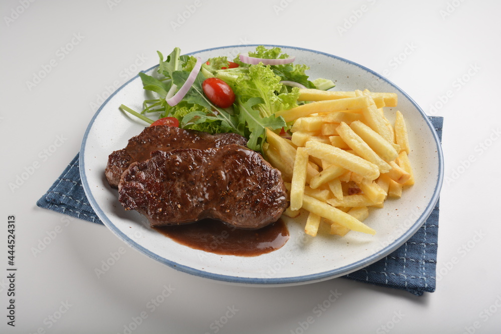 bbq grilled juicy wagyu beef tenderloin sirloin steak in brown black pepper sauce with French fries and vegetables salad dressing western cuisine menu