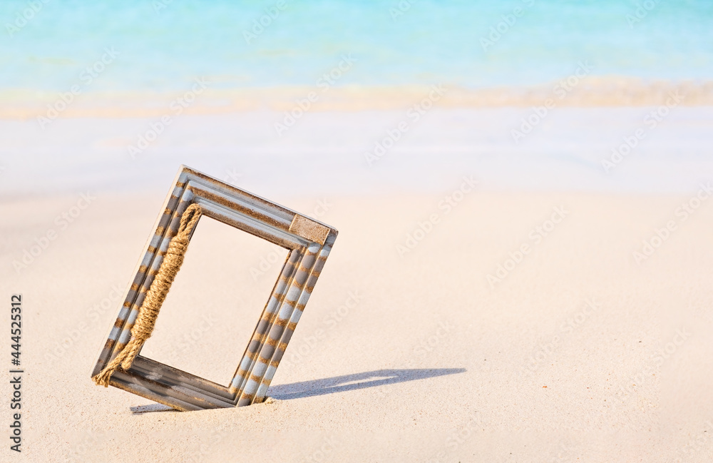 Wooden Photo frame on the tropical sea sand and the beach background with copy space Wooden Photo frame on the tropical sea sand and the beach background with copy space