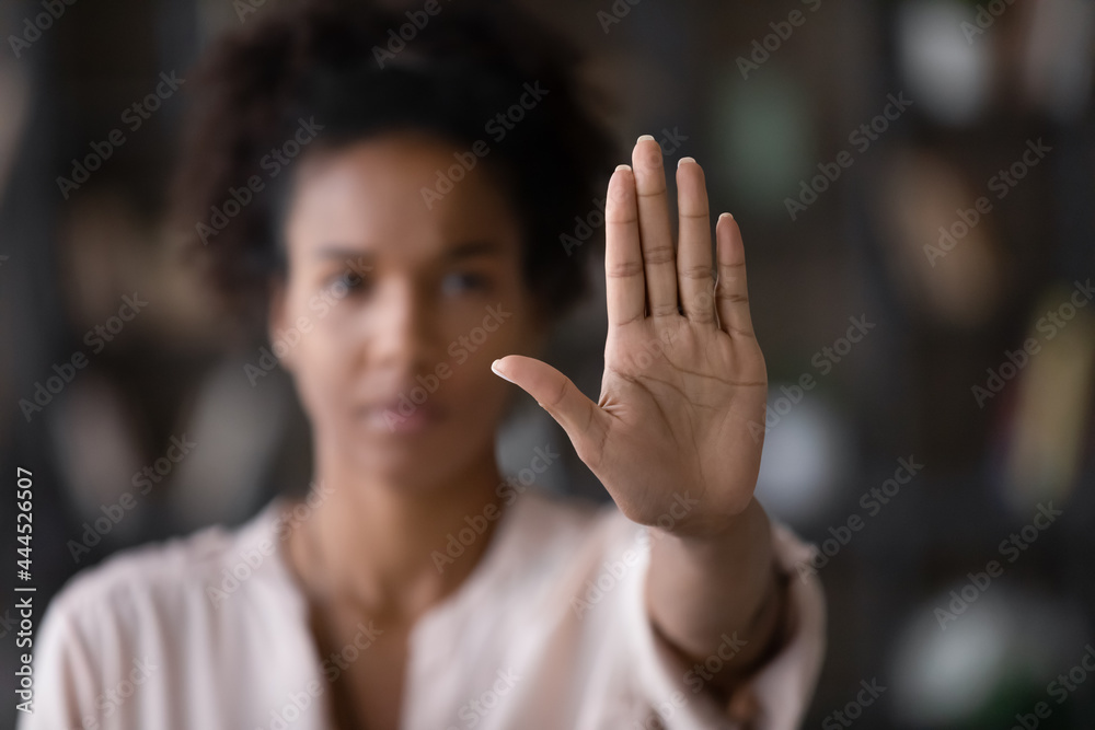 Close up of African American woman showing stop gesture with hand blurred background, young female protesting against domestic violence and abuse, bullying, saying no to gender discrimination - obrazy, fototapety, plakaty 
