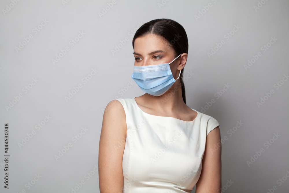 Young woman wearing medical face mask, studio portrait Young woman wearing medical face mask, studio portrait