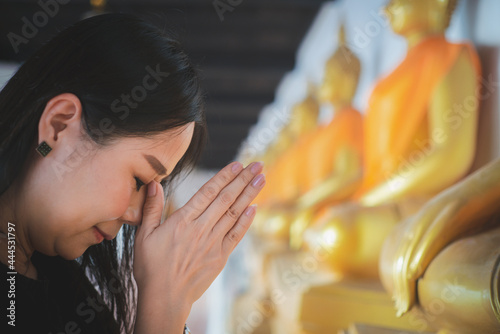 Asian woman pays homage to the Buddha statue with respect and faith