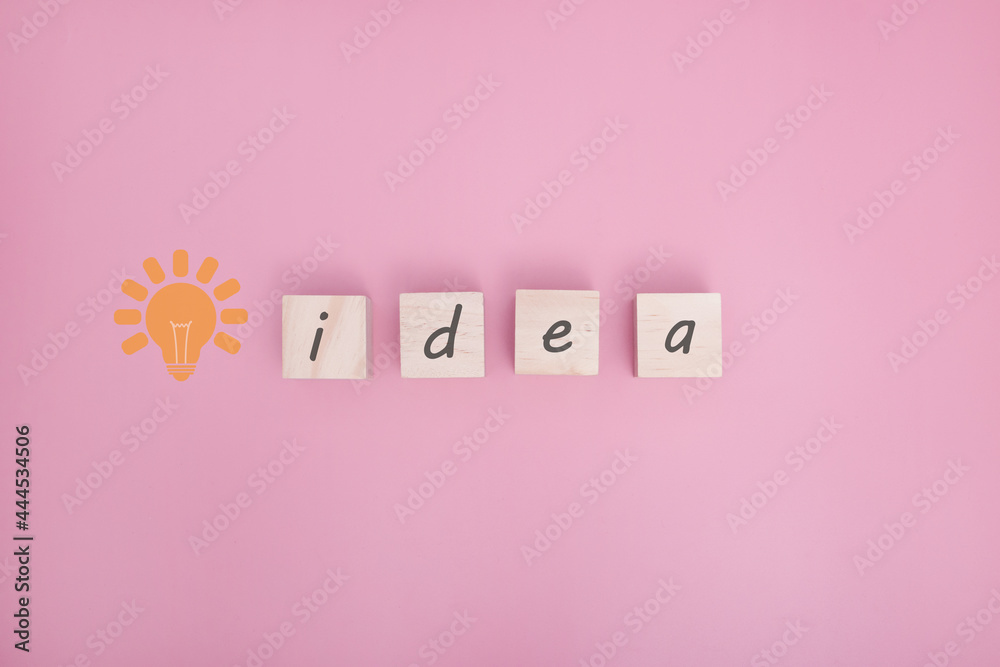 Arranging wood cube with idea text on pink background with free text space.