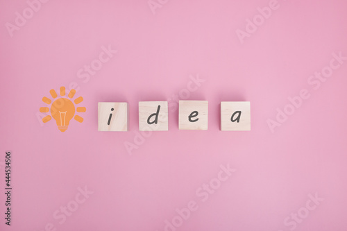 Arranging wood cube with idea text on pink background with free text space.