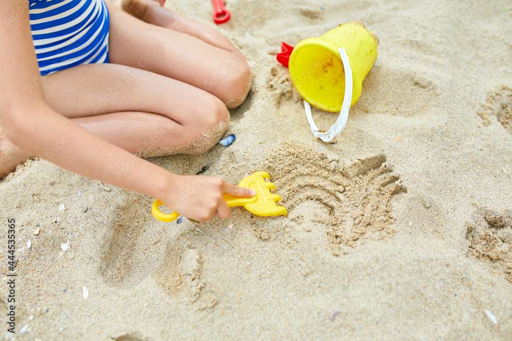 Little kid having fun on the beach and playing with sand toys Little kid having fun on the beach and playing with sand toys
