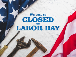 LABOR DAY. Hand tools and the Flag of the United States of America lying on the table. View from above, close-up. Congratulations to family, relatives, friends and colleagues. National holiday concept