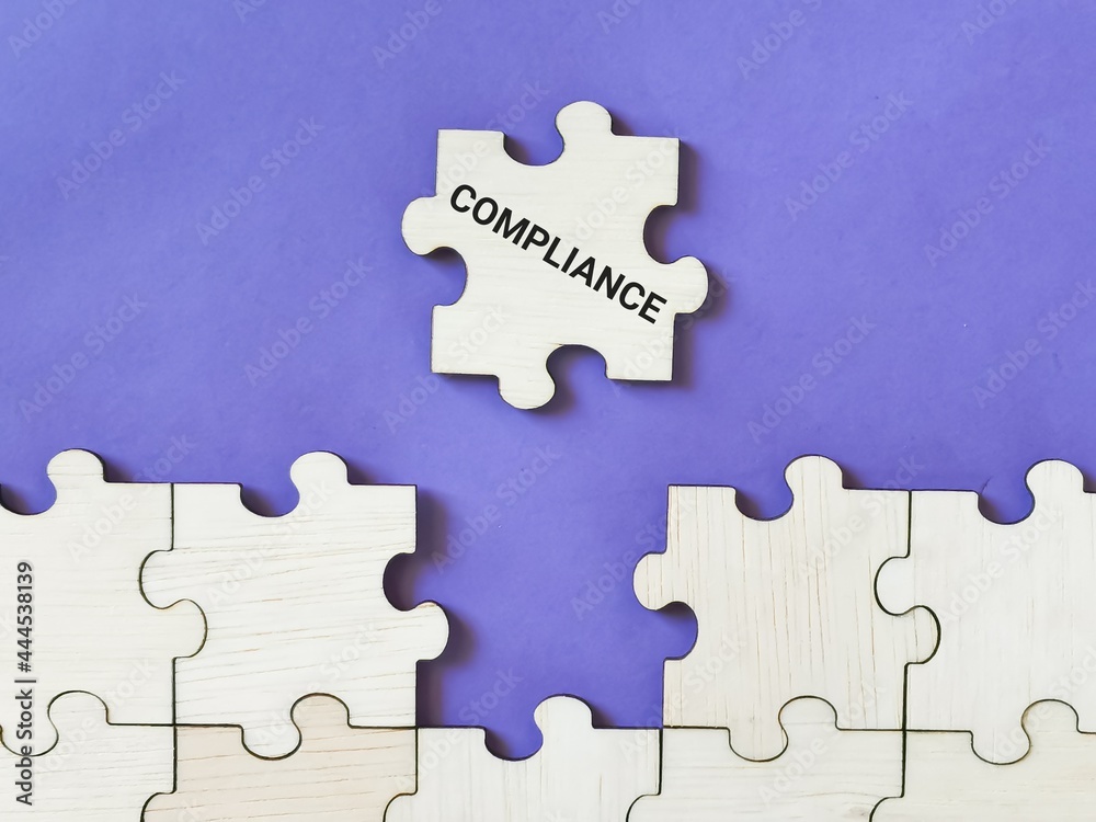 Fototapeta premium Selective focus phrase compliance on wooden jigsaw puzzle against purple background.