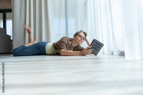 middle aged woman reading a e book