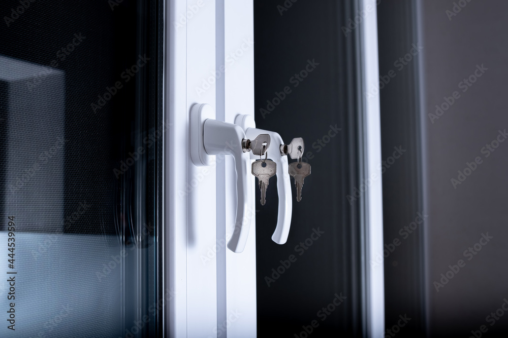 The concept of protecting a child from falling out of windows. Handle with a lock on the window. The concept of protecting a child from falling out of windows. Handle with a lock on the window.