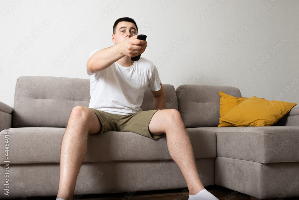 Man sitting on couch at home and watching TV Man sitting on couch at home and watching TV