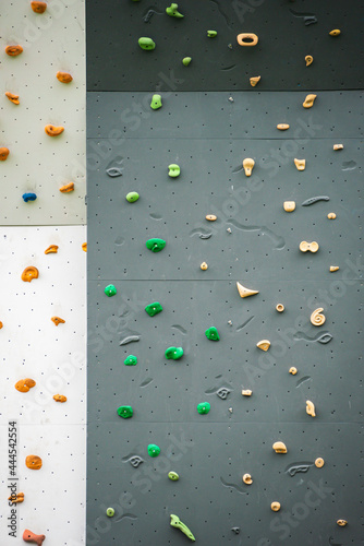 Abstract colorful of rock climbing wall with toe and hand hold studs, various colored grips at outdoor gym adventure park. © mckornik