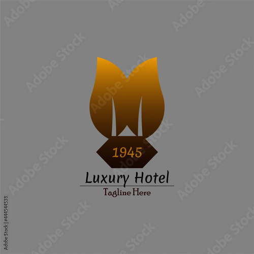 image of a luxury hotel logo with a green building concept, which is depicted with two gold leaves and has been around for a long time. This logo is also suitable for healthy luxury restaurant busines
