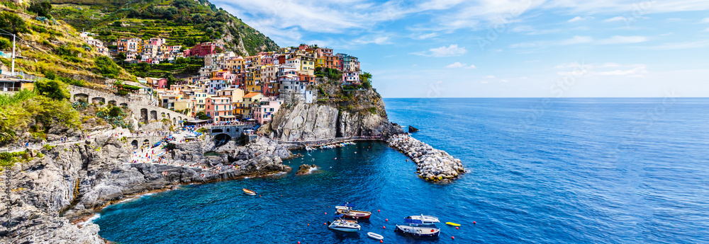 view of the colorful houses along the coastline of Cinque Terre area in Riomaggiore, Italy