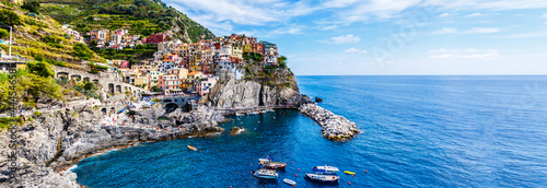 view of the colorful houses along the coastline of Cinque Terre area in Riomaggiore, Italy