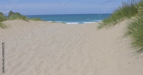 Seaside scene with sand dunes and waves in Cornwall photo