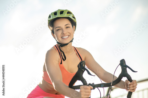 Female cyclist in protective helmet llooking happy and contented photo