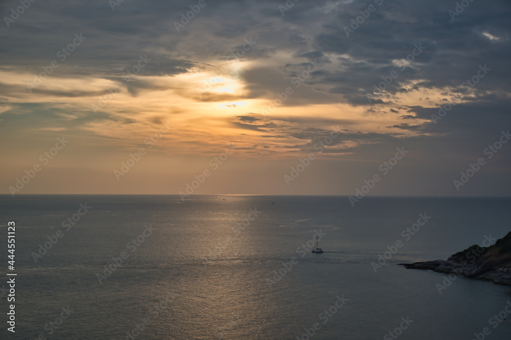 Beautiful, stunning panoramic view of the golden sky and reflections on the Andaman sea during the sunset at Promthep Cape landmark viewpoint in Phuket,