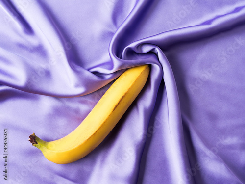 Sexy concept with banana on crumpled silk sheet photo