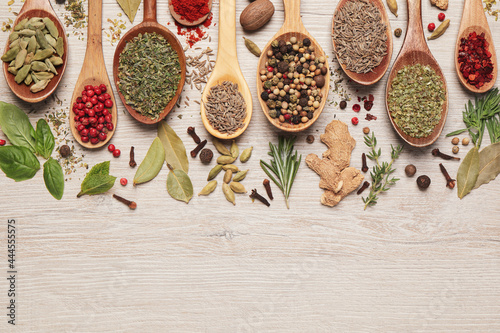 Fototapeta Naklejka Na Ścianę i Meble -  Different natural spices and herbs on light wooden table, flat lay. Space for text