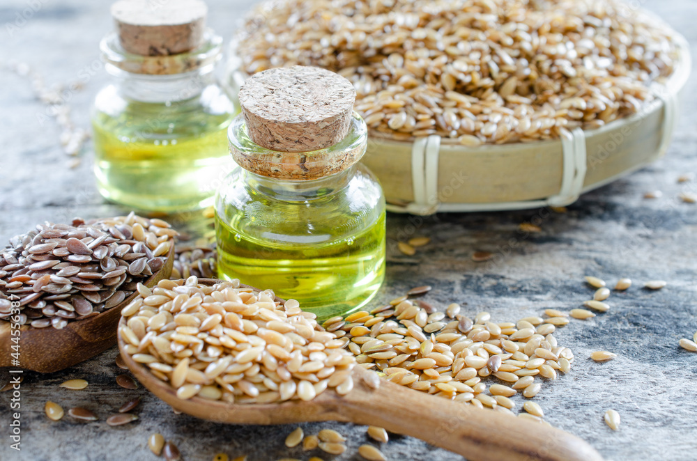 Closed up organic flax seed essential oil in glass bottle on grunge wooden background Closed up organic flax seed essential oil in glass bottle on grunge wooden background