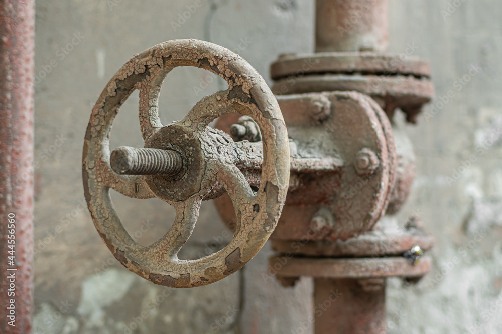 Old rusty valve on an old rusty pipe, close-up.