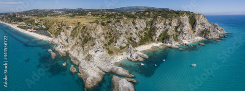 Aerial view of Capo Vaticano, Calabria, Italy. Lighthouse and promontory. Rocks overlooking the sea. Praia I Focu beach and A Ficara beach. Boats and bathers and crystal clear sea. Costa degli Dei
