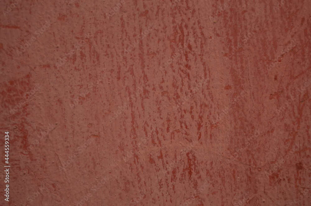 pale red background with streaks of paint. Wall, surface, color, background, texture, streams