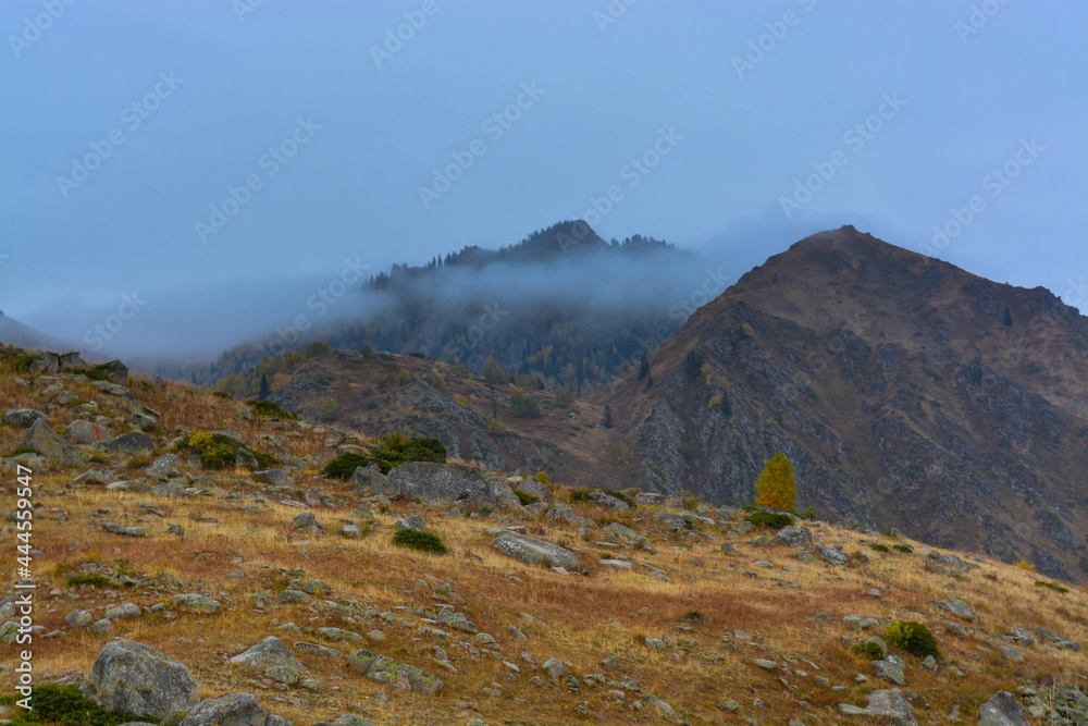 Mountains in the fog. Fall. Overcast. Ile-Alatau mountains, Almaty region, Kazakhstan. Mountains in the fog. Fall. Overcast. Ile-Alatau mountains, Almaty region, Kazakhstan.