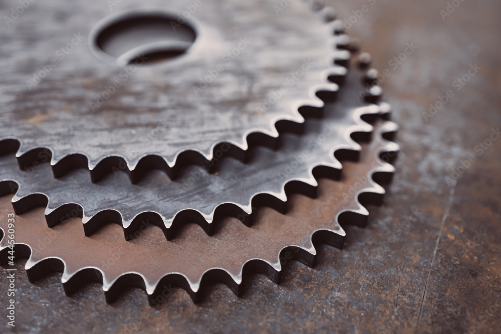 three large metal gears on the background of a metal surface three large metal gears on the background of a metal surface