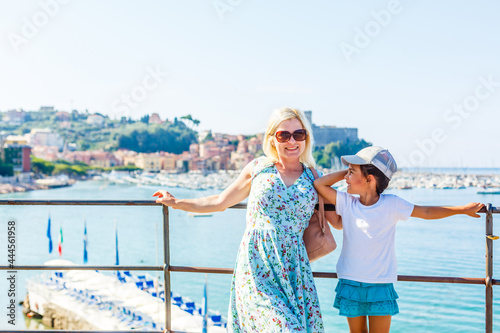 happy young mother with little daughter near sea, mother and daughter near the sea of italy