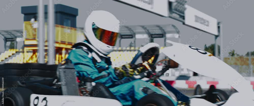 TRACKING Front view of teenager professional racer driving his go kart on a race track. Shot with 2x anamorphic lens