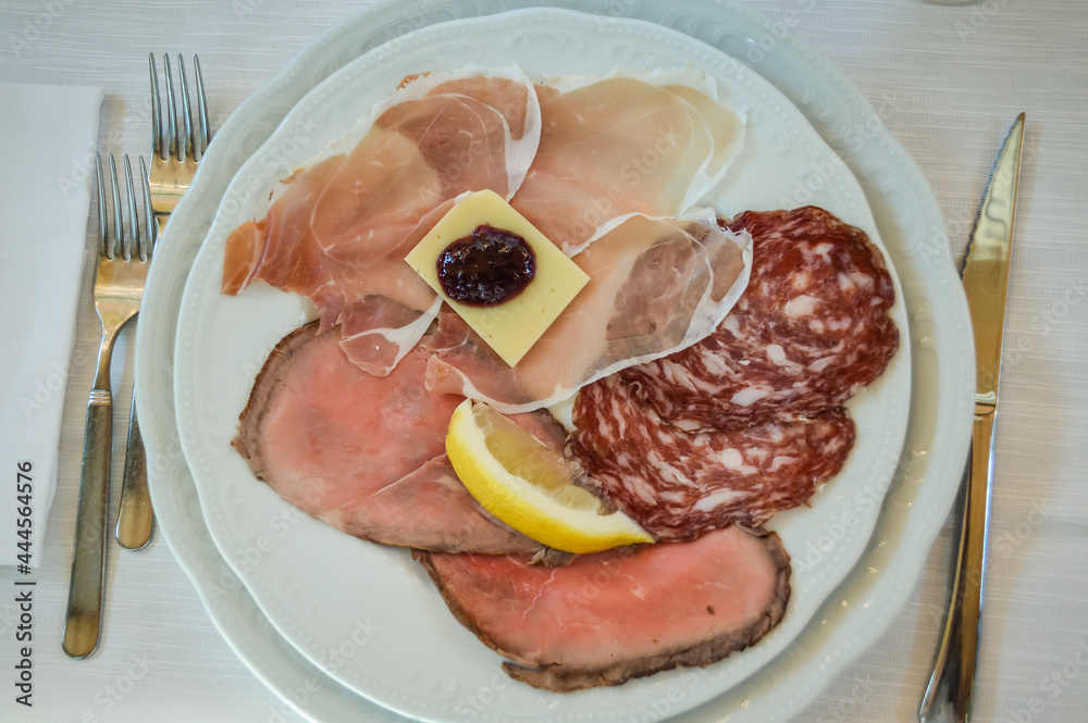 Italian antipasto in a plate at restaurant, with prosciutto, roast beef