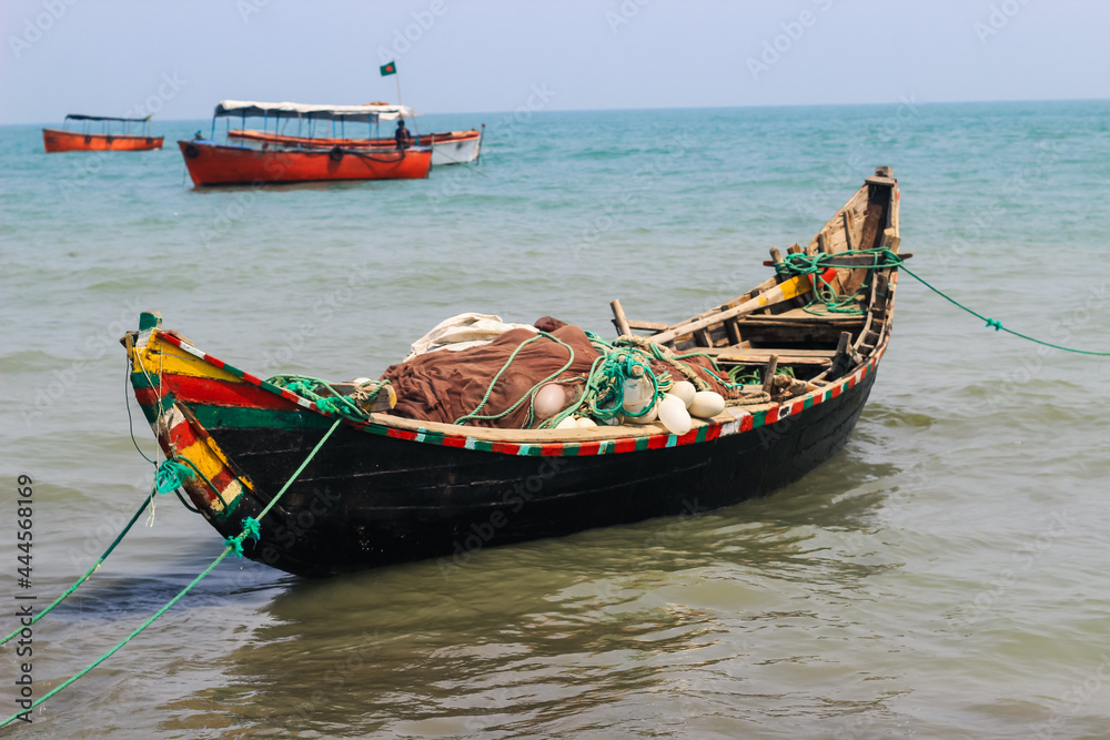 Bangladeshi traditional fishing boat on St. Martin's Island. Fisherman preparing boat for sailing into the ocean. Colorful fishing boats.