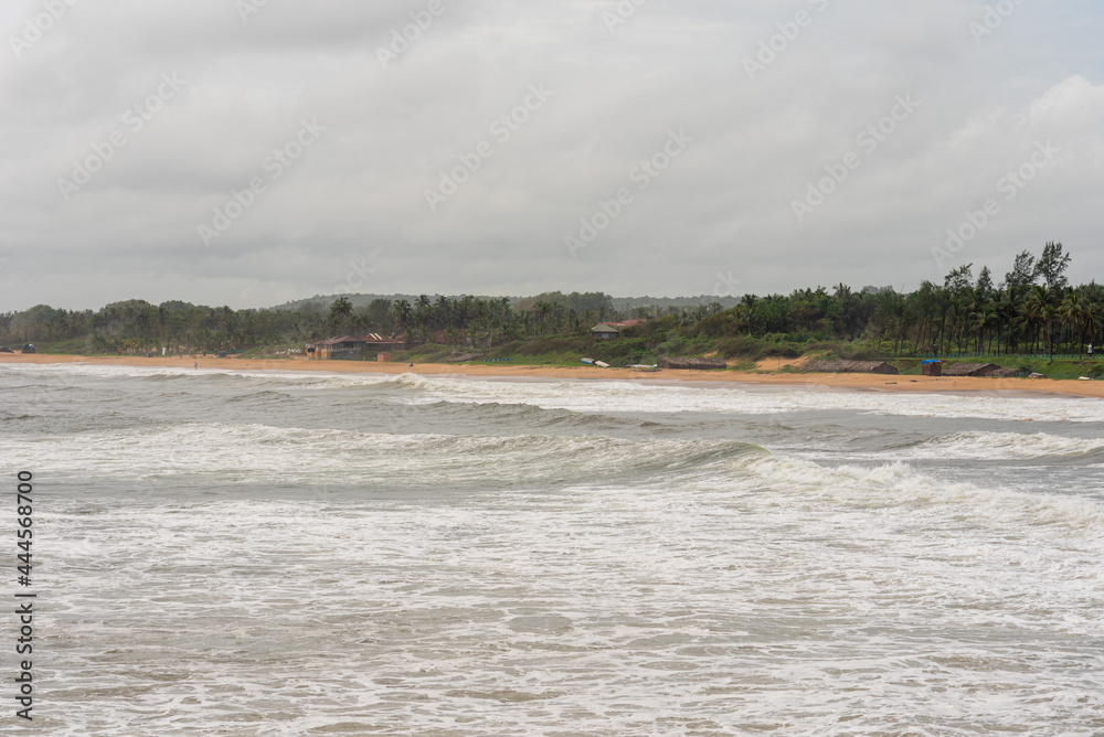 Waves crashing on the Sinquerim fort with the beach landscape in the background in Goa Waves crashing on the Sinquerim fort with the beach landscape in the background in Goa
