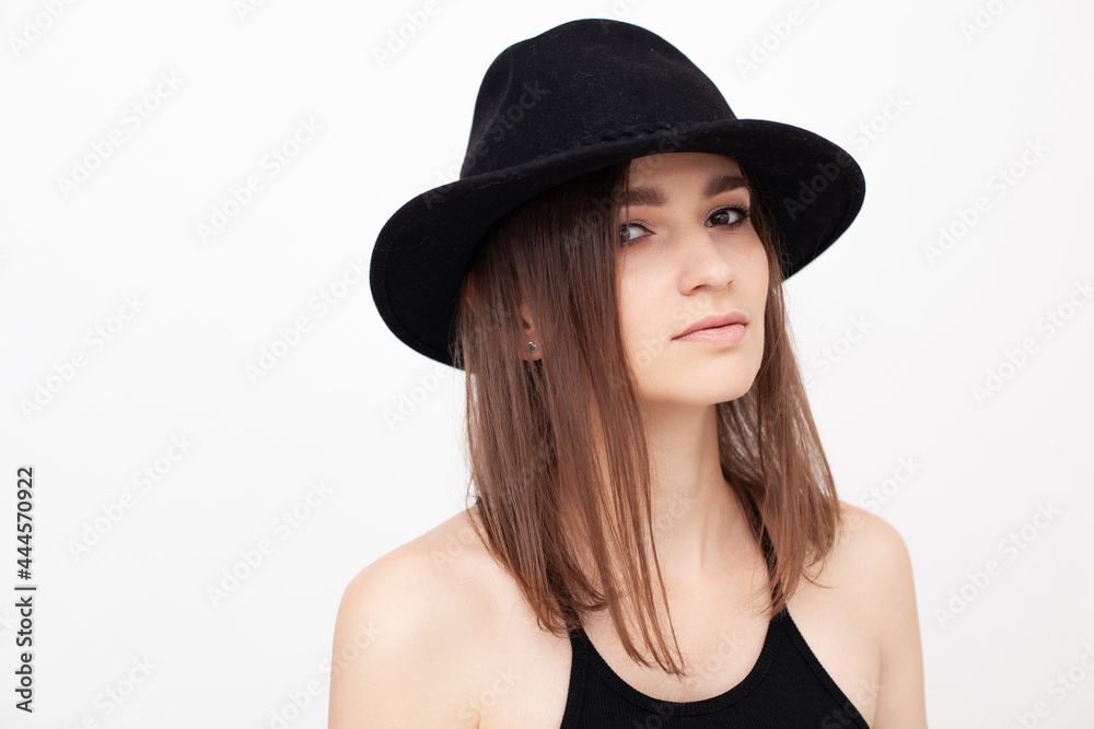 Portrait of a girl with beautiful eyes looking in the camera wearing black hat in the studio Portrait of a girl with beautiful eyes looking in the camera wearing black hat in the studio