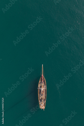 Aerial view of a tall mast sailing ship on a calm turquoise ocean