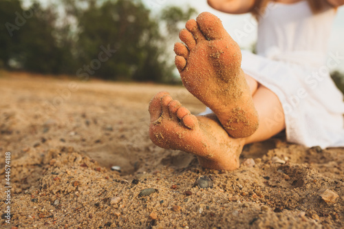 Obraz na plátně Women's feet on the yellow sand by the sea. The concept of travel