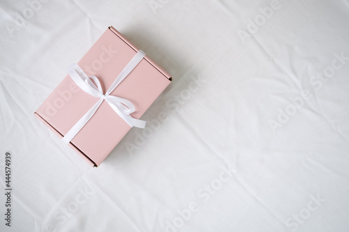 One gift wrapped in pink paper with an elegant white bow. for someone special.