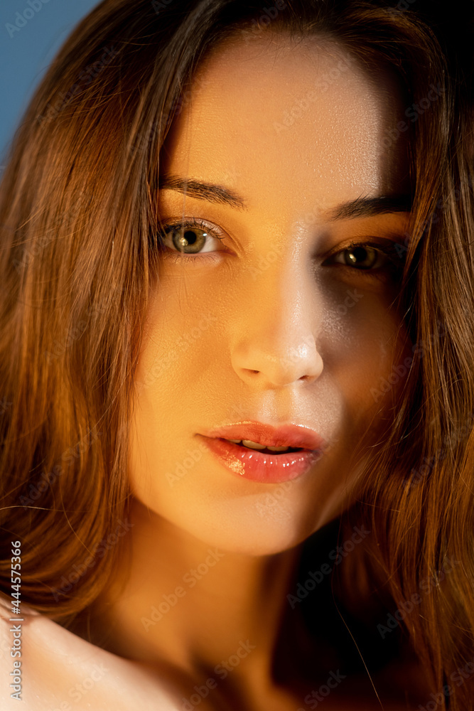 Fototapeta premium Attractive woman. Natural beauty. Facial rejuvenation. Healthy skin. Close up portrait of appealing young female with clean smooth flawless face in warm light.