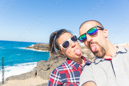 Happy young couple taking a selfie at seaside