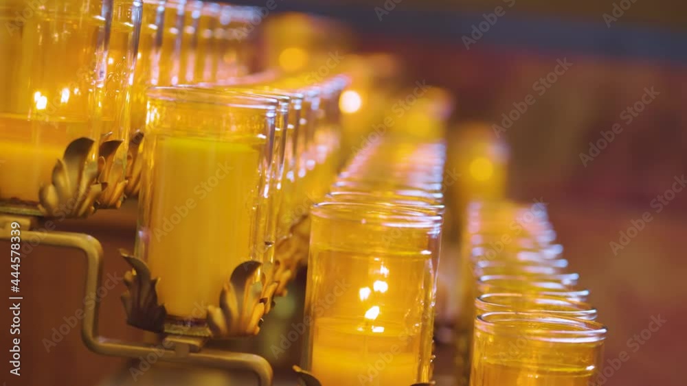 close up view of candle slowly burning a warm glow within a catholic